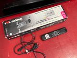 a box with a remote and a remote control on a red table