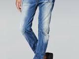 Cet homme porte une chemise noire et un jean bleu.