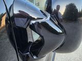 a reflection of a man in the side view mirror of a car