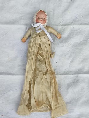 une poupée allongée sur un drap blanc