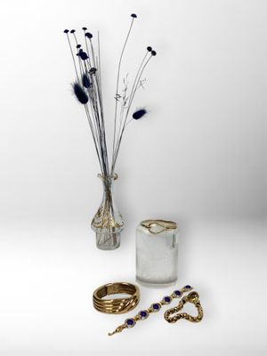 un vase avec des fleurs et une paire de bagues sur la table
