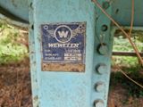 une pancarte apposée sur le flanc d'une machine qui se trouve dans l'herbe
