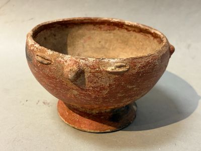 a small brown bowl sitting on top of a white table