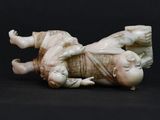 a figurine of a baby laying on a black surface