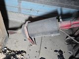 an image of a dirty exhaust pipe in a garage