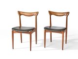 une paire de chaises avec des assises en cuir noir sur fond blanc