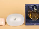 une photo d'un flacon de parfum à côté d'un porte-savon