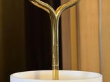 a white vase with a gold handle on a table