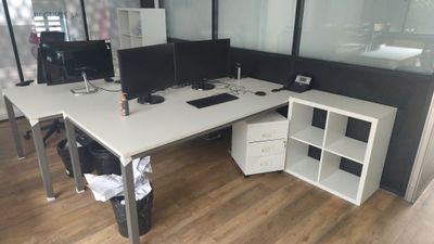 un bureau blanc sur lequel sont posés deux écrans d'ordinateur