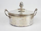 une cocotte ancienne en métal argenté, avec un couvercle et des poignées