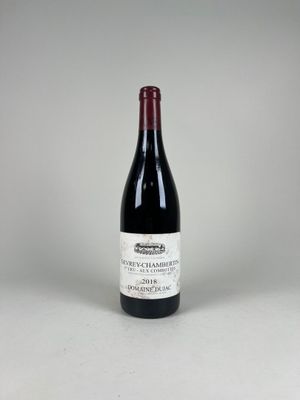 une bouteille de vin rouge posée sur une table blanche