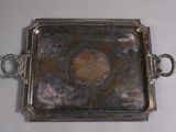 a metal tray with a handle and handles on a table
