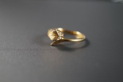 Gros plan sur une bague en or ornée d'une fleur