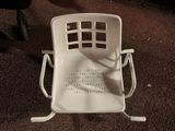 a white plastic chair sitting on a carpeted floor