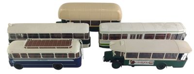 quatre petits bus qui sont rangés les uns à côté des autres