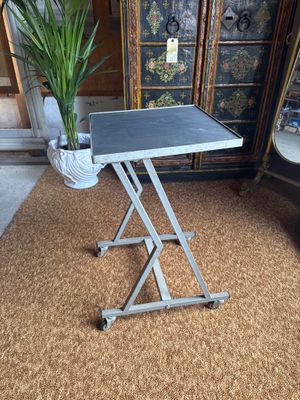 a small table with a plant on it in the middle of a room