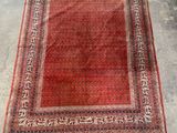 un tapis rouge et noir posé sur un sol en béton