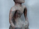 an image of a statue of a person sitting on a rock