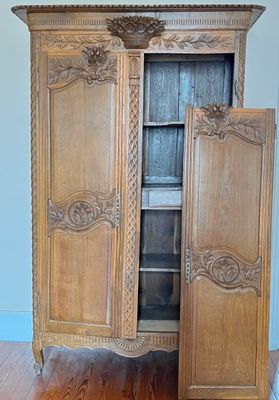 a wooden armoire with a door open on a hard wood floor
