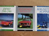 trois livres posés sur une table, avec une voiture rouge et une voiture bleue