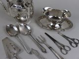 a lot of silverware on a table with spoons and utensils