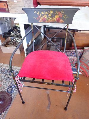 a red chair with a red cushion on it in front of a fireplace