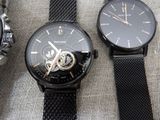 three watches sitting on a table with a black strap