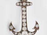 an anchor shaped broochle with diamonds on a white background