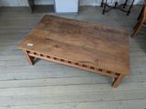 une table basse en bois posée sur un parquet, dans une pièce