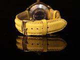 the watch is yellow and has a black face on it
