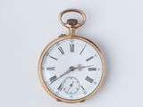une montre de poche en or avec des chiffres romains