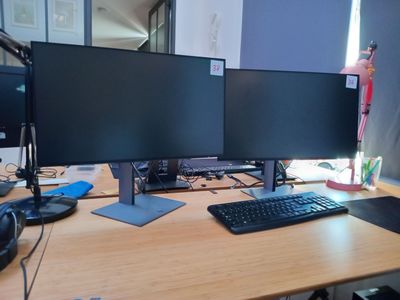 un bureau équipé de deux écrans et d'un clavier