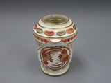 un vase blanc orné d'un motif rouge et jaune