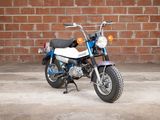 a blue and white motorcycle parked in front of a brick wall