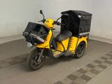 un scooter jaune avec une housse noire à l'arrière