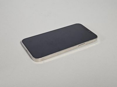 un iPhone 6s argenté posé sur une surface blanche