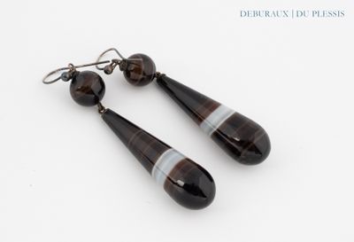 une paire de boucles d'oreilles en verre à rayures noires et blanches sur fond blanc