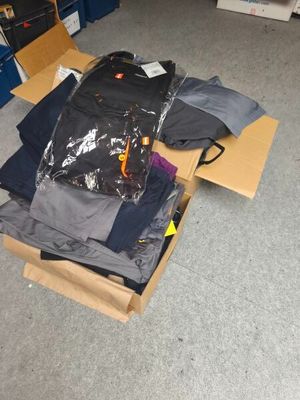 a pile of clothes in a cardboard box on the floor
