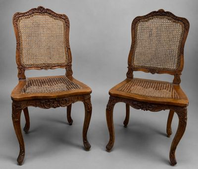 une paire de chaises anciennes avec dossier et assise en rotin