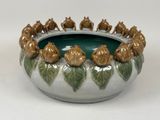 a green and white bowl with a bunch of animals in it