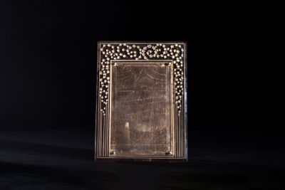 an old photo frame sitting on top of a wooden table