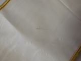 a close up of a white shirt with a gold trim