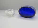une bouteille en verre bleue posée à côté d'une bouteille en verre vide