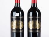 deux bouteilles de vin rouge posées l'une à côté de l'autre sur une surface blanche