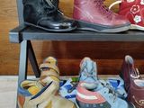 several pairs of children ' s shoes sit on a shelf in a room