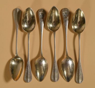 six cuillères sont alignées sur une table