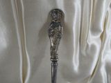 a silver spoon with a bird on it sitting on a table