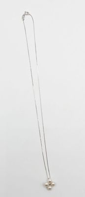 Collier plaqué argent orné d'une étoile et d'une perle sur fond blanc