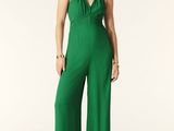 an image of a woman in a green jumpsuit posing for a picture