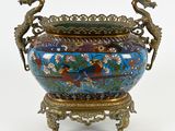 a large vase with two birds on it on a stand